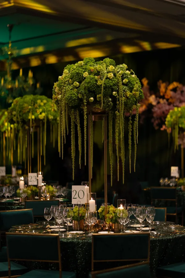 Tall green centerpiece with trailing amaranthus over a candlelit gala table