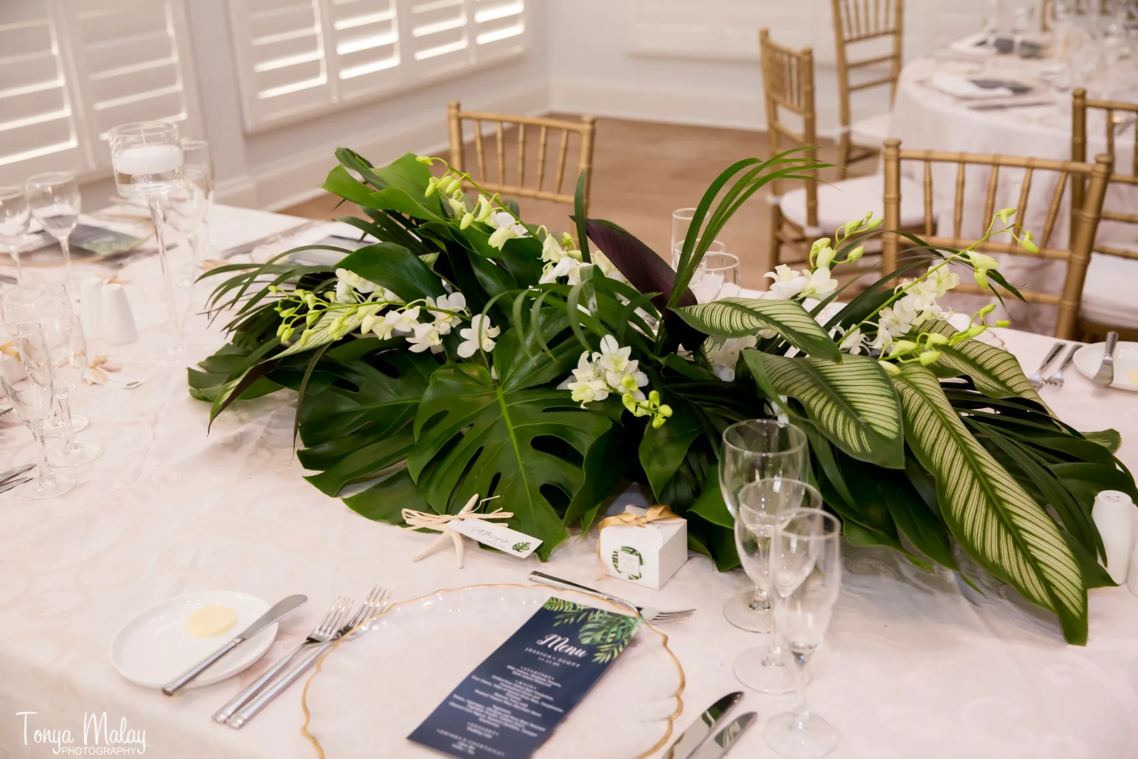 Monstera and orchid runner laid down a reception table