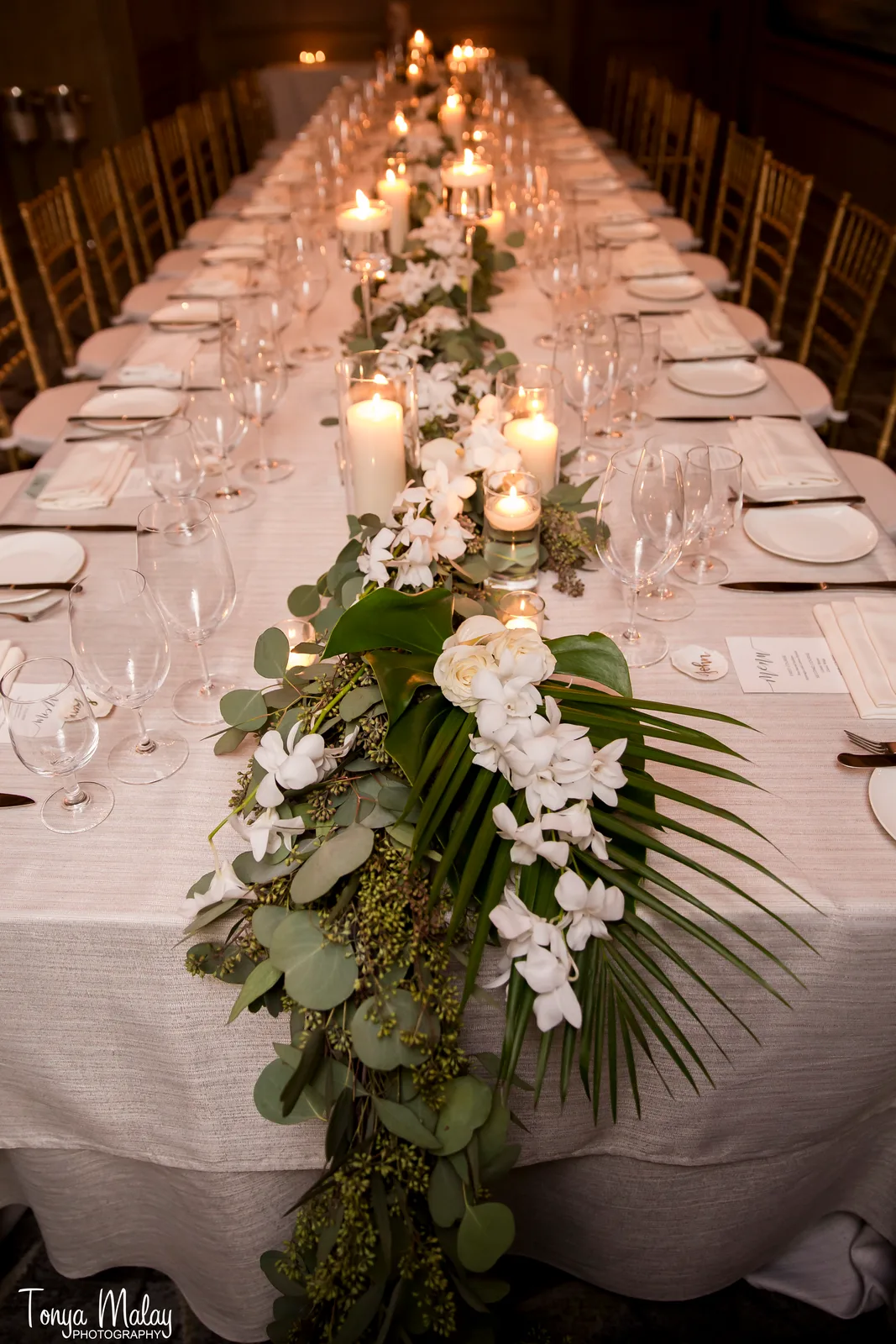 Orchid and eucalyptus garland with candles down the dinner table
